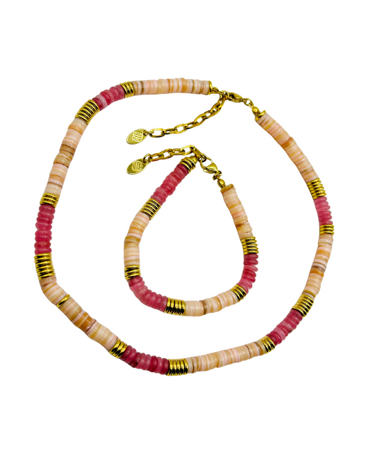 Necklace with pink, beige, and gold beads on a white background. Close-up of Fynn Set beaded necklace with gold-tone spacers.