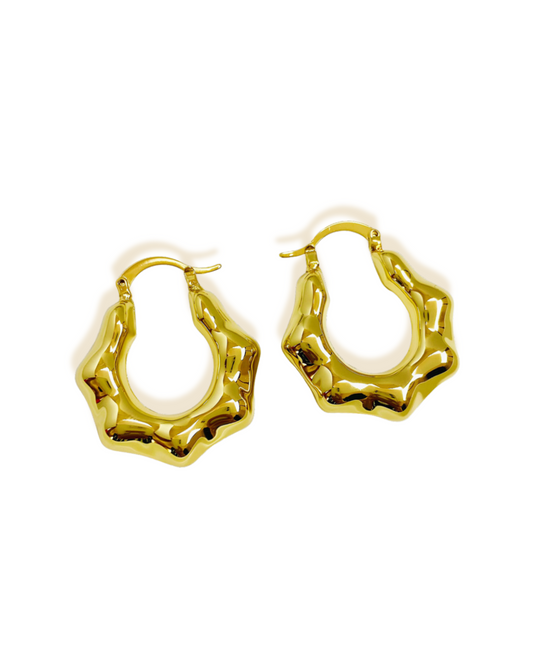 Lumi Earring Gold hoop earrings on a white background. Lumi gold wavy hoop earrings on white background.