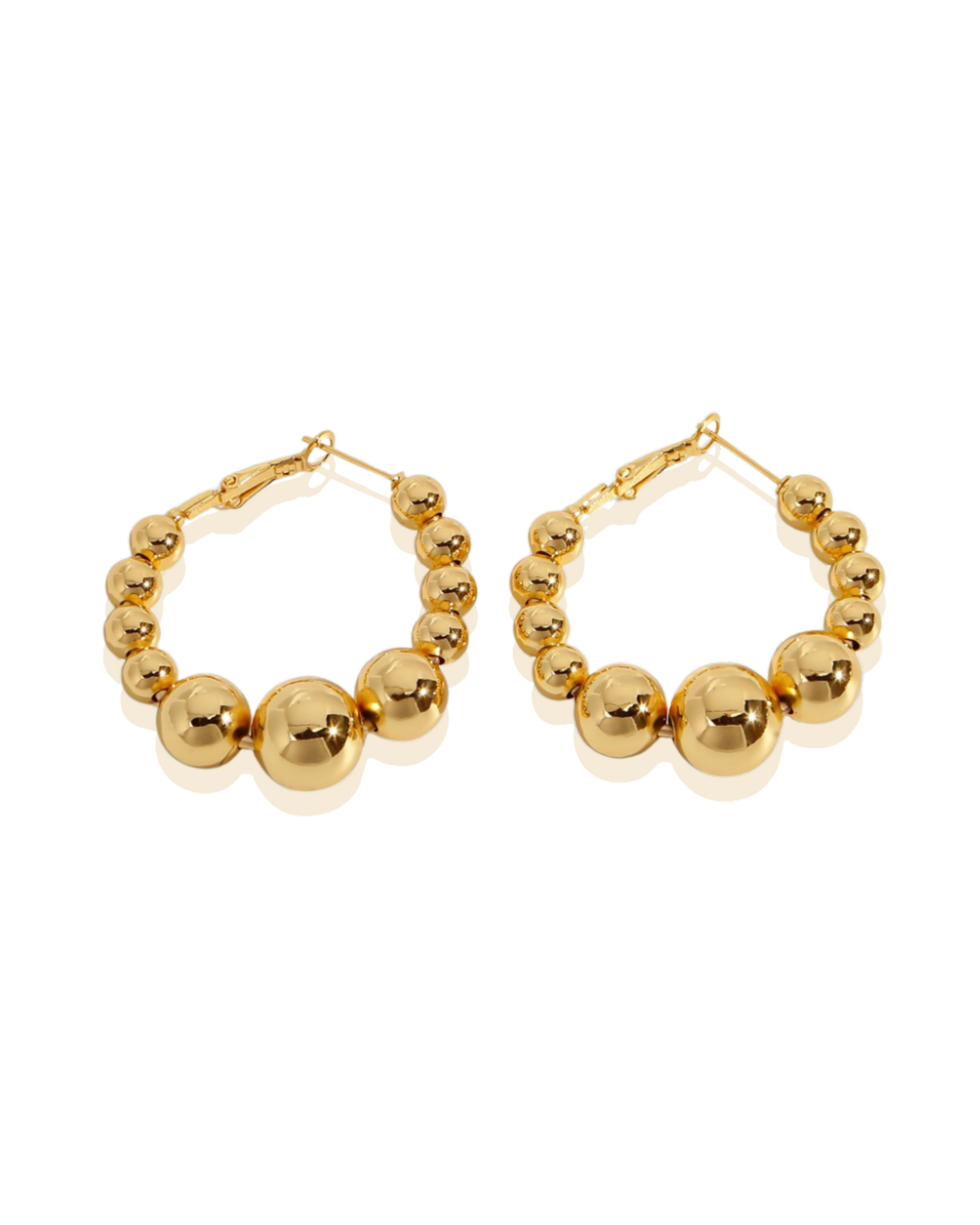 Aria Earring A pair of gold-plated hoop earrings with beaded details for women on a white background. Close-up of Aria earrings showing graduated gold beads and reflective finish