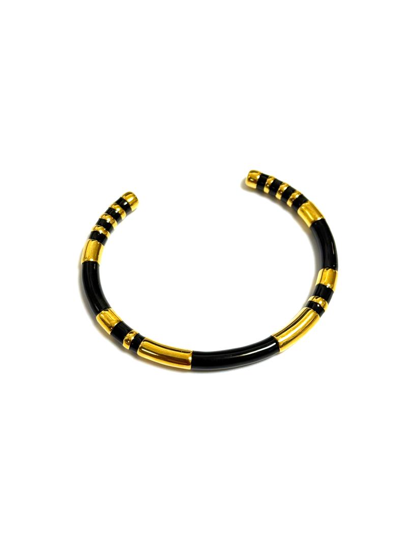 A bold chic bangle bracelet with a gold-plated finish, featuring black stripes and branded with the name 'BOLD'.