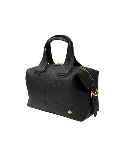 Black handbag with gold accents on a white background. Black Maya Handbag front view with gold hardware and adjustable strap.