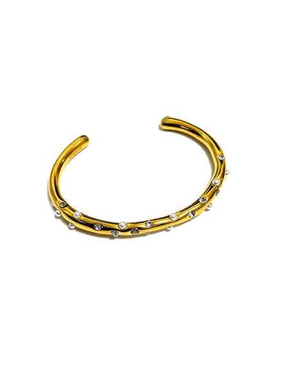 A gold-colored cuff bracelet with lustrous pearls and dazzling crystals, presented against a white background.