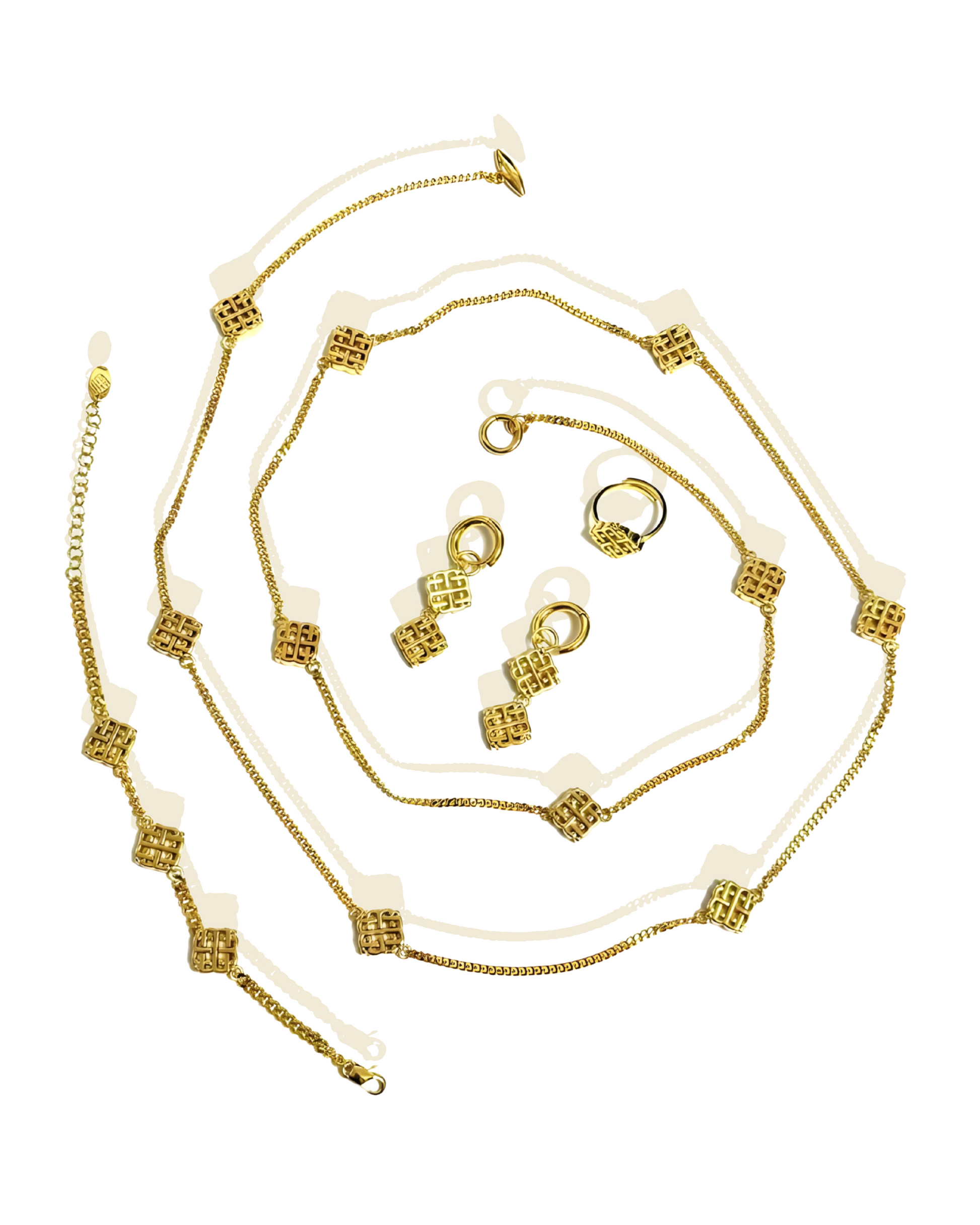 A set of vintage jewelry including a necklace, bracelet, earrings, and ring, with gold plating and geometric motifs.