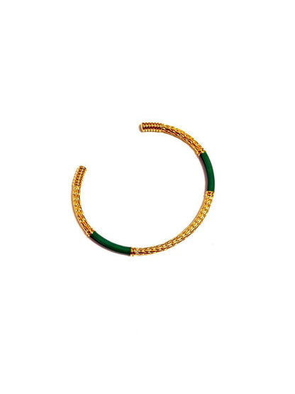 Model wearing Lydia Cuff gold enamel bracelet – minimalist adjustable statement cuff. An 18k gold-plated c-shaped cuff bangle bracelet with gold-tone metalwork and multicolored enamel detailing.