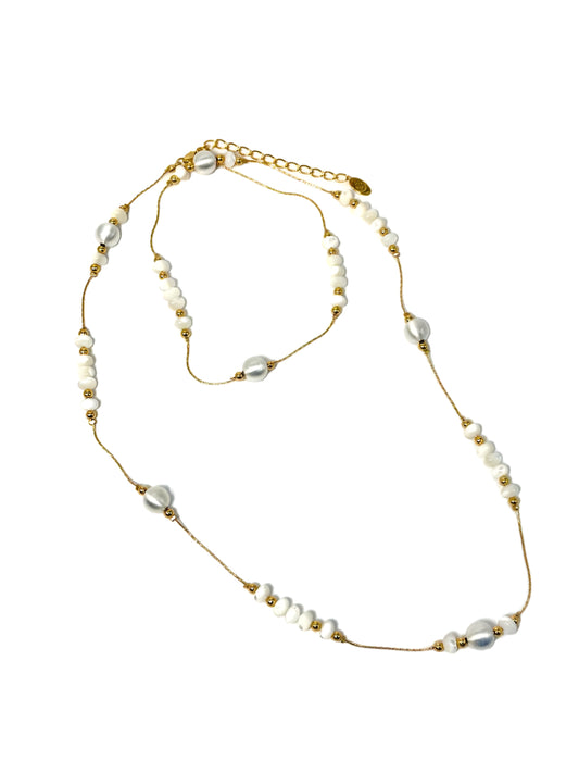 A long 18 karat gold-plated necklace with small and large white beads, featuring a clasp fastening.