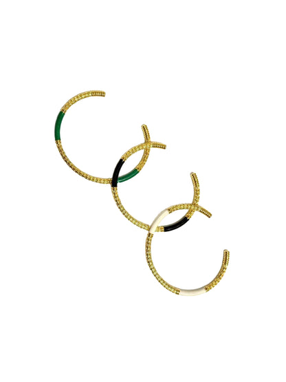 An 18k gold plated c-shaped cuff bangle bracelet with gold-tone metalwork and green oil-based enamel detailing.