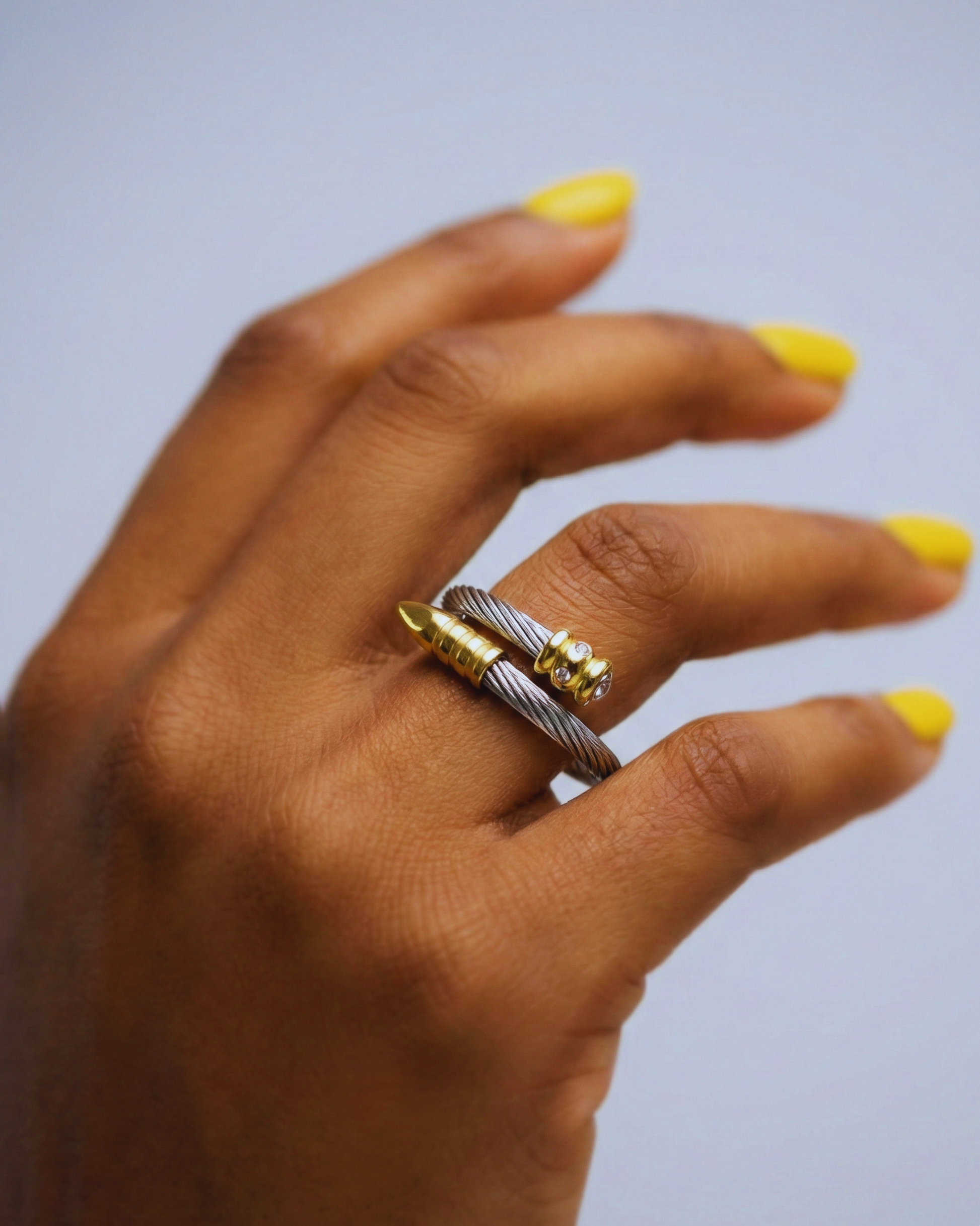 female hand wearing one silver rings with yellow gold accents & Crystal detail