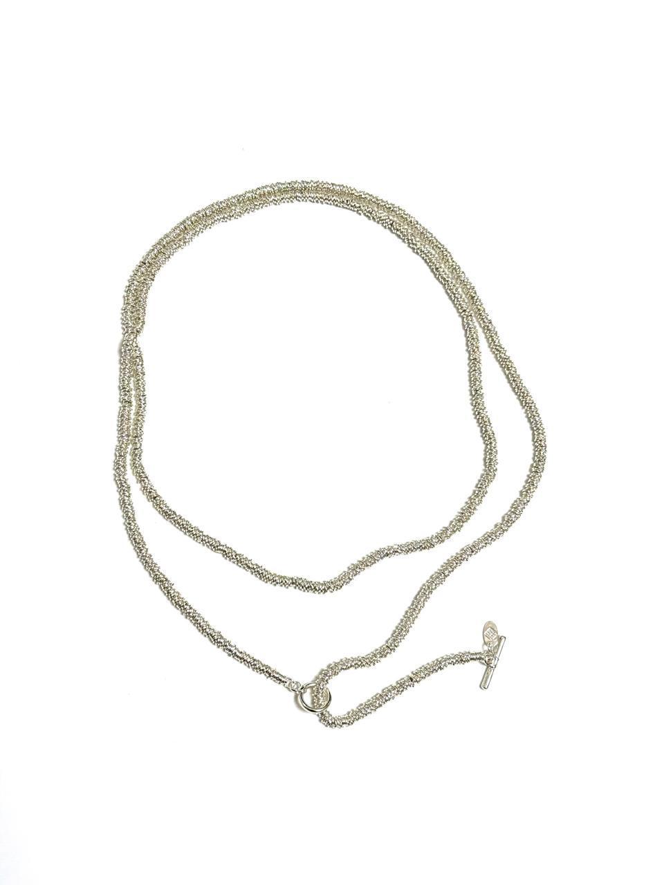 A long, coiled design plated necklace with a toggle clasp, featuring mixed metals and colors silver and gold.