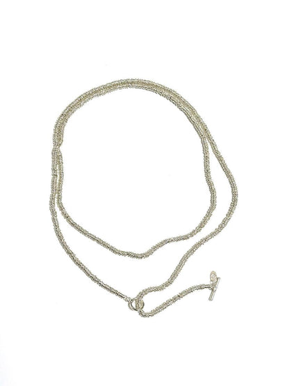 A long, coiled design plated necklace with a toggle clasp, featuring mixed metals and colors silver and gold.