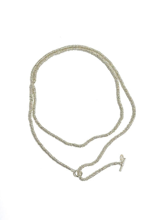 A long, coiled design plated necklace with a toggle clasp, featuring mixed metals and colors silver and gold.